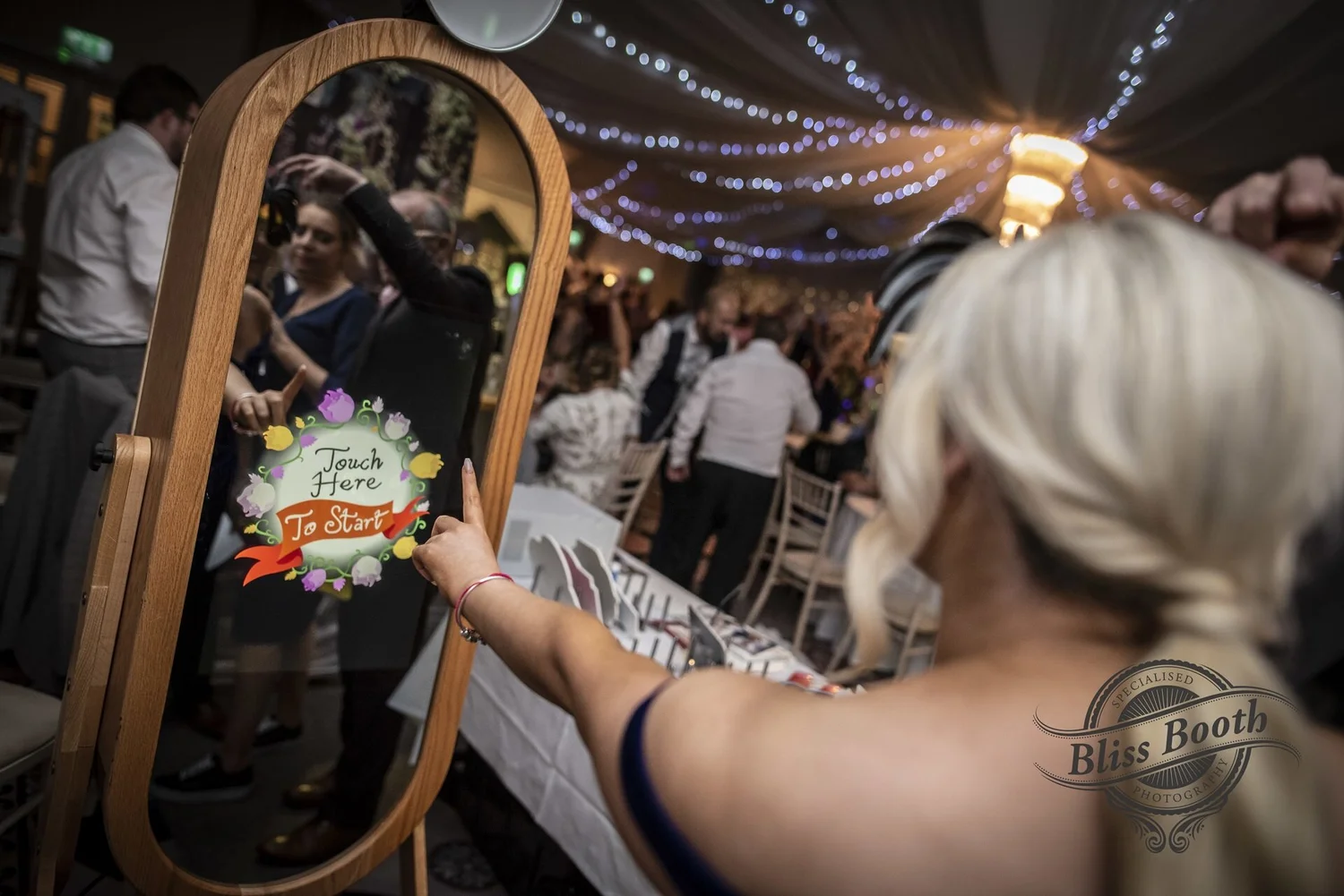 Guest tapping the Retro Magic Mirror at an evening reception