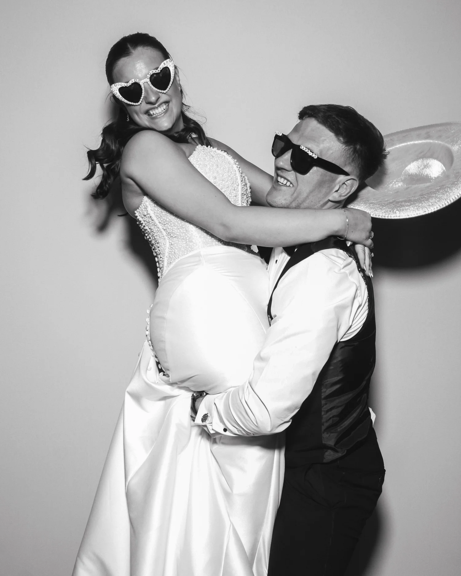Bride and groom posing for a photo booth picture at Hazel Gap Barn wedding venue in Nottinghamshire with Bliss Booth's ICON Photo Booth.