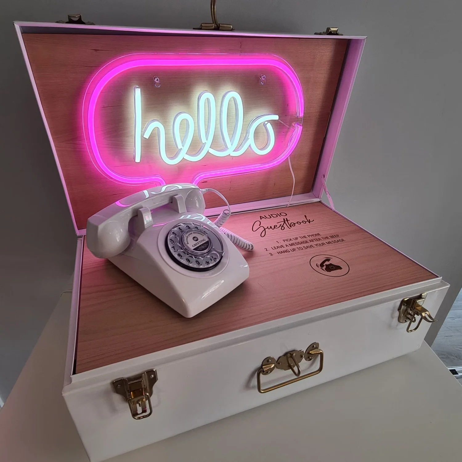 Audio guest book telephone box with a neon hello sign and vintage white phone