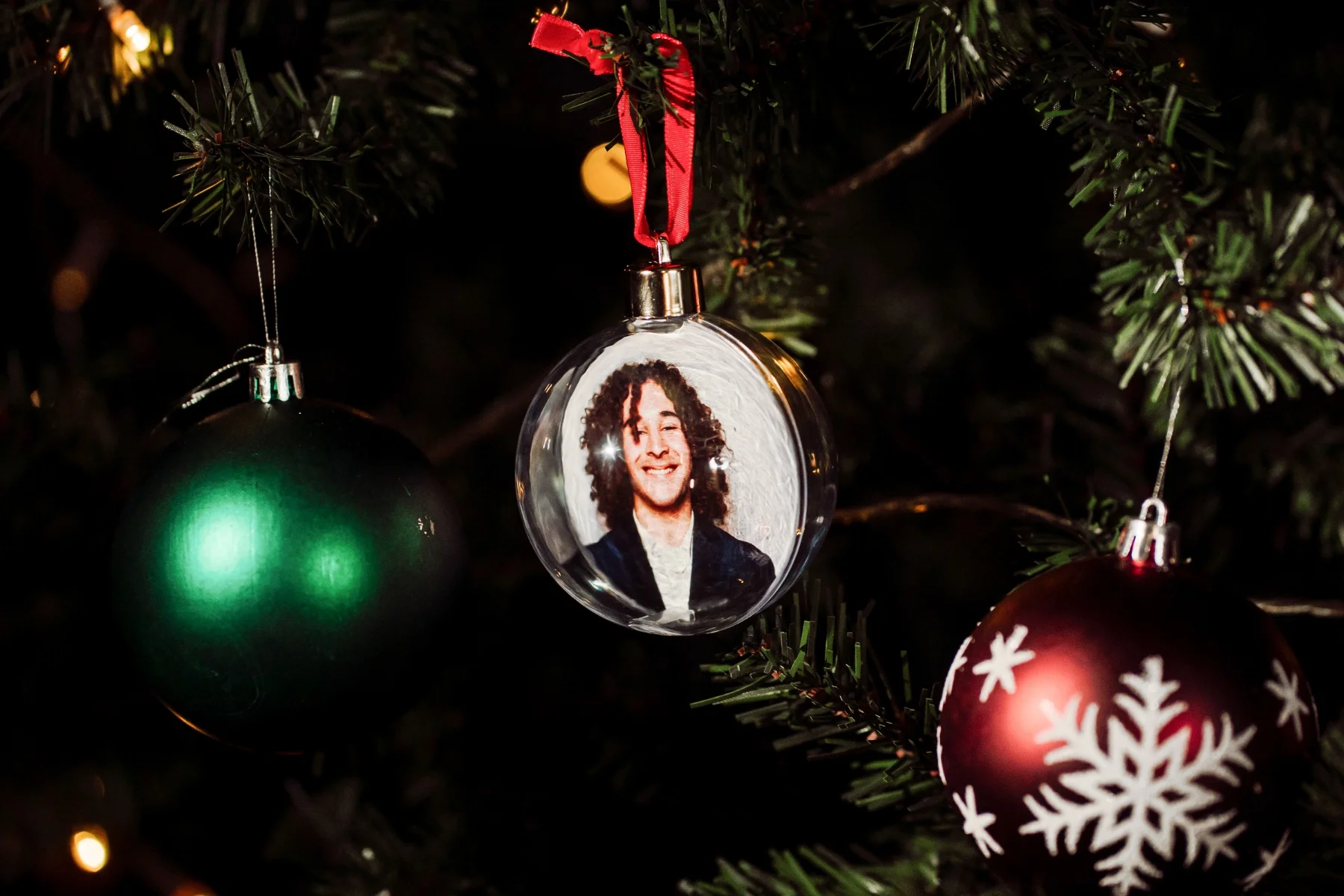 Personalised photo bauble hanging on a Christmas tree