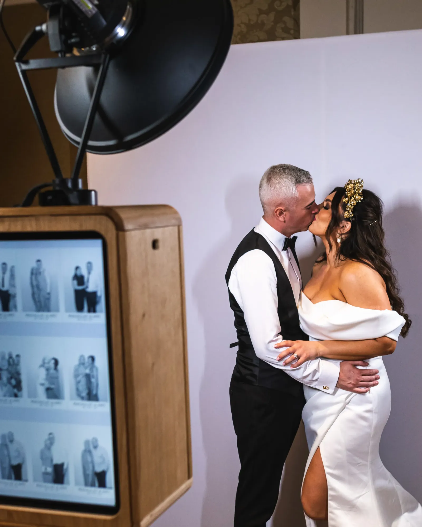 Couple kissing beside the wooden ICON photo booth at their wedding