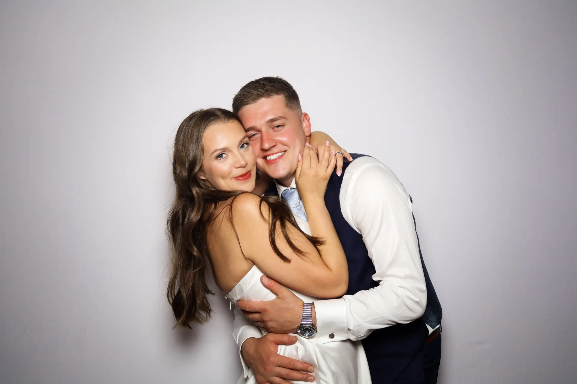 Bride and groom hugging in the photo booth on their wedding day