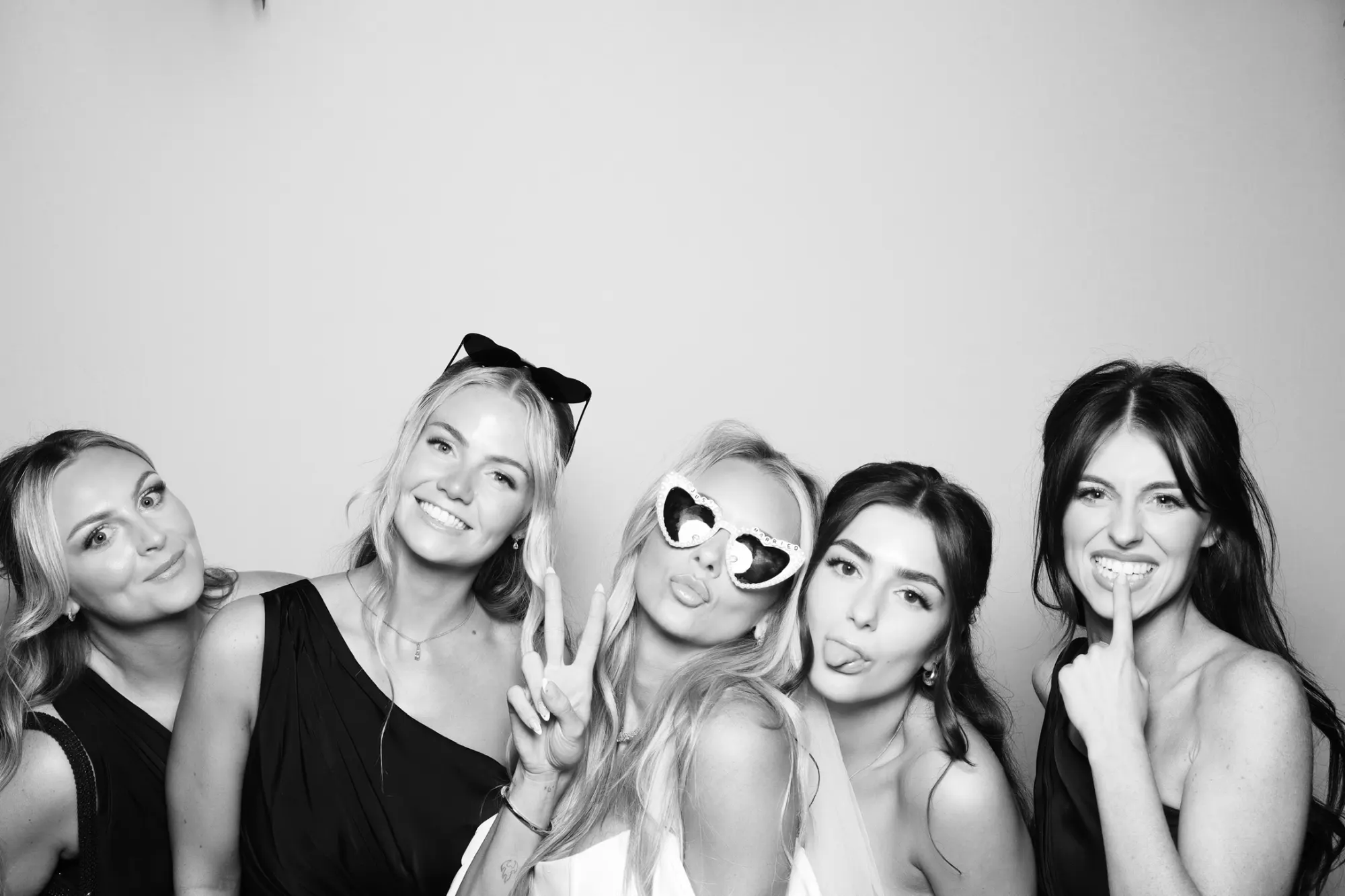 Bride and bridesmaids in Just Married glasses in a black and white wedding photo booth picture