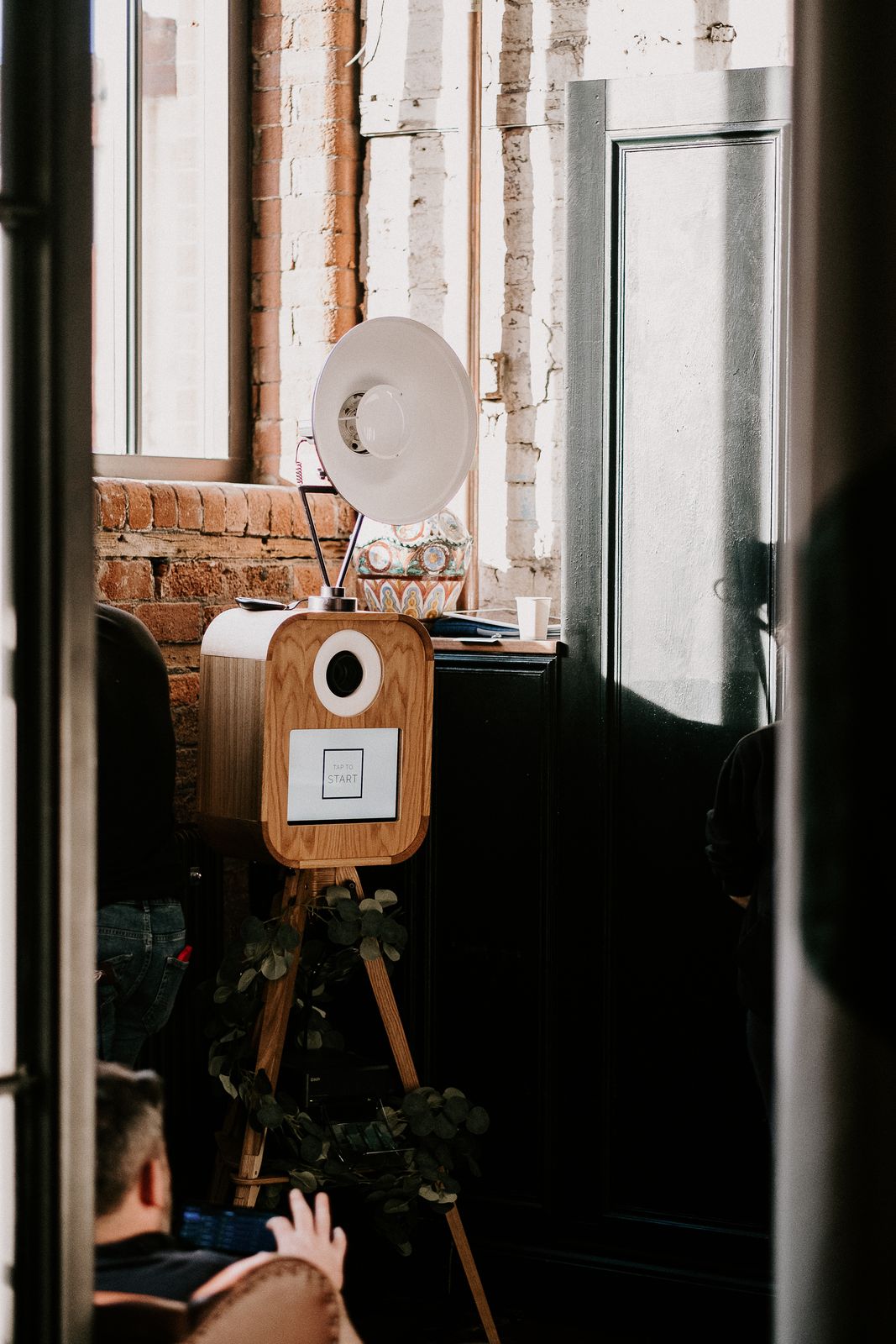 Retro photo booth with studio light set up in a rustic brick wedding venue