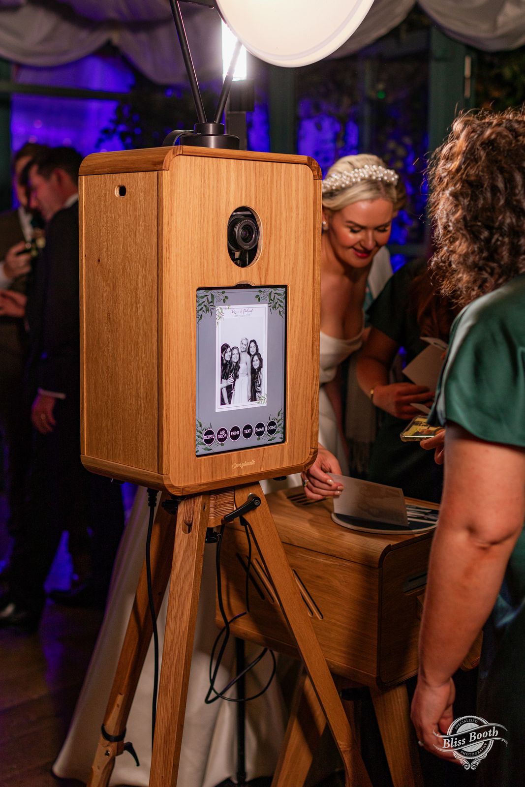 Guests crowding round the ICON photo booth at a wedding party