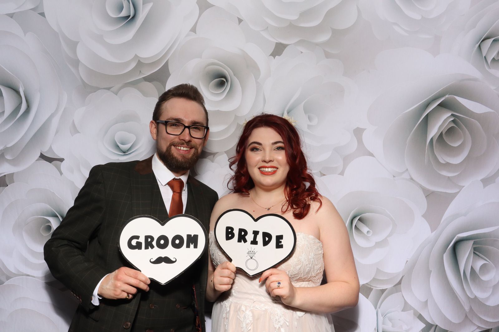 Bride and groom holding Groom and Bride signs in the Retro photo booth