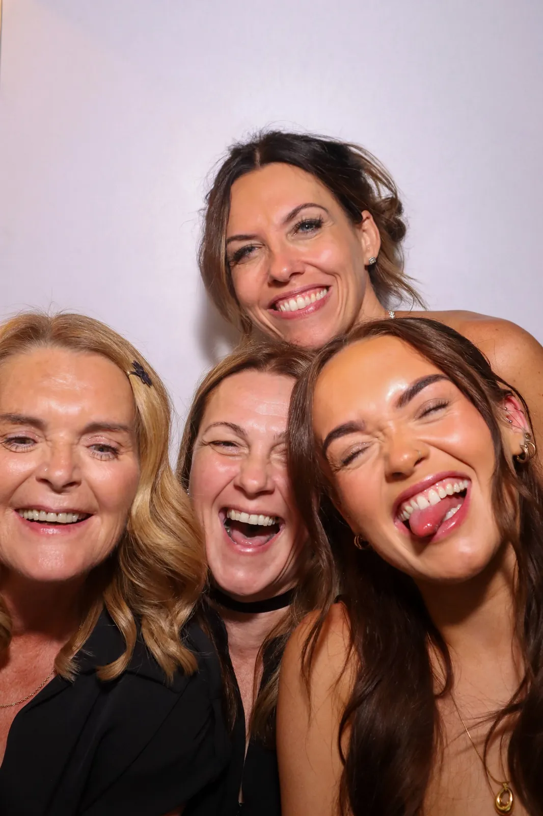 Four women laughing in the Photomatic photo booth