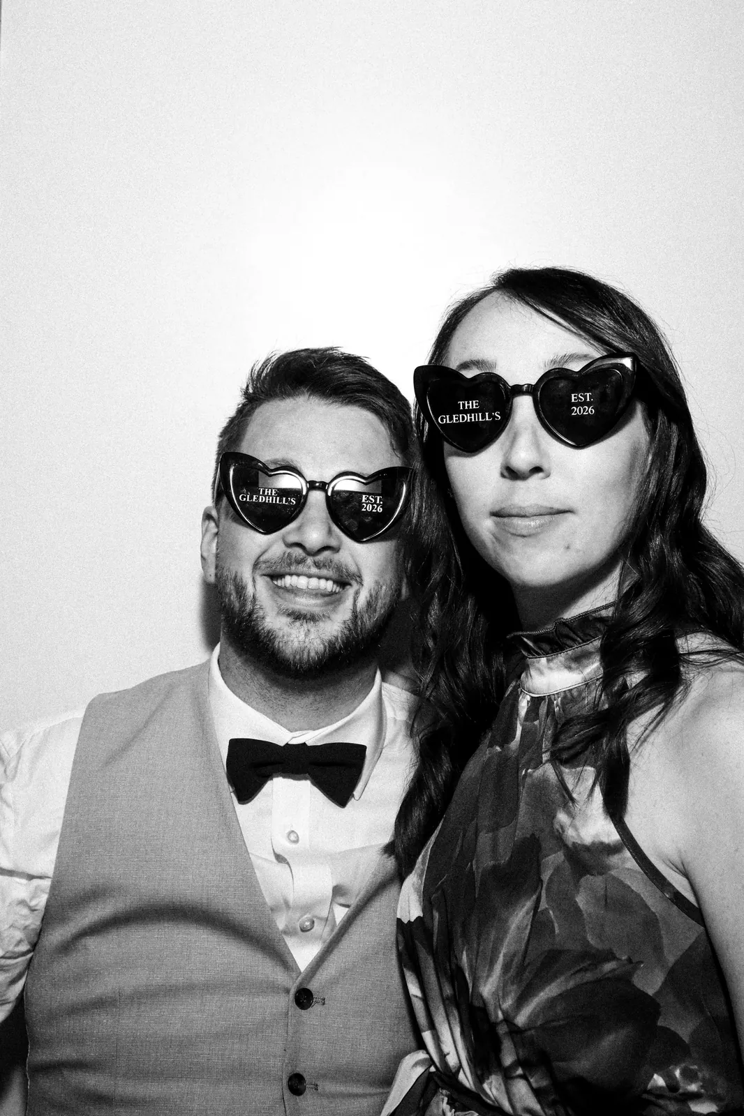 Couple in personalised wedding heart sunglasses in the Photomatic booth