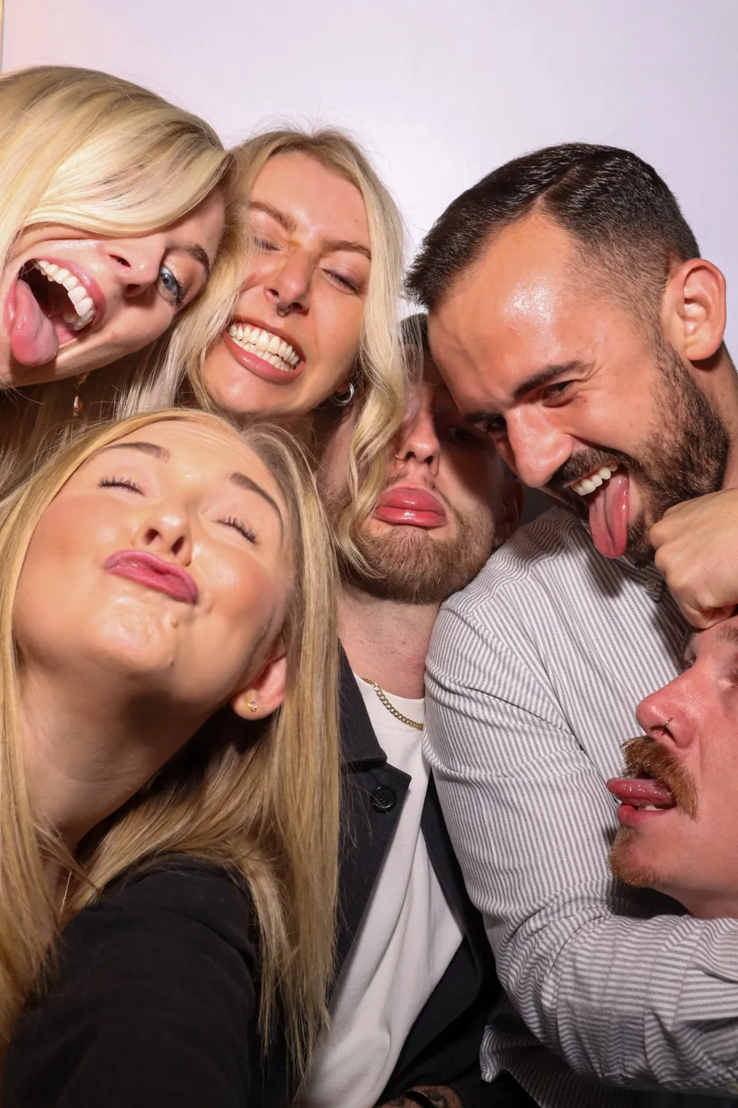Friends pulling silly faces together in the Photomatic photo booth
