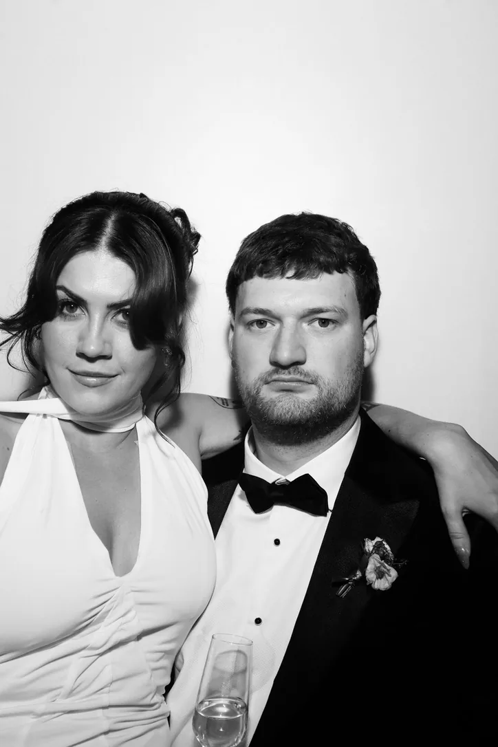 Bride and groom posing together in the Photomatic photo booth, black and white