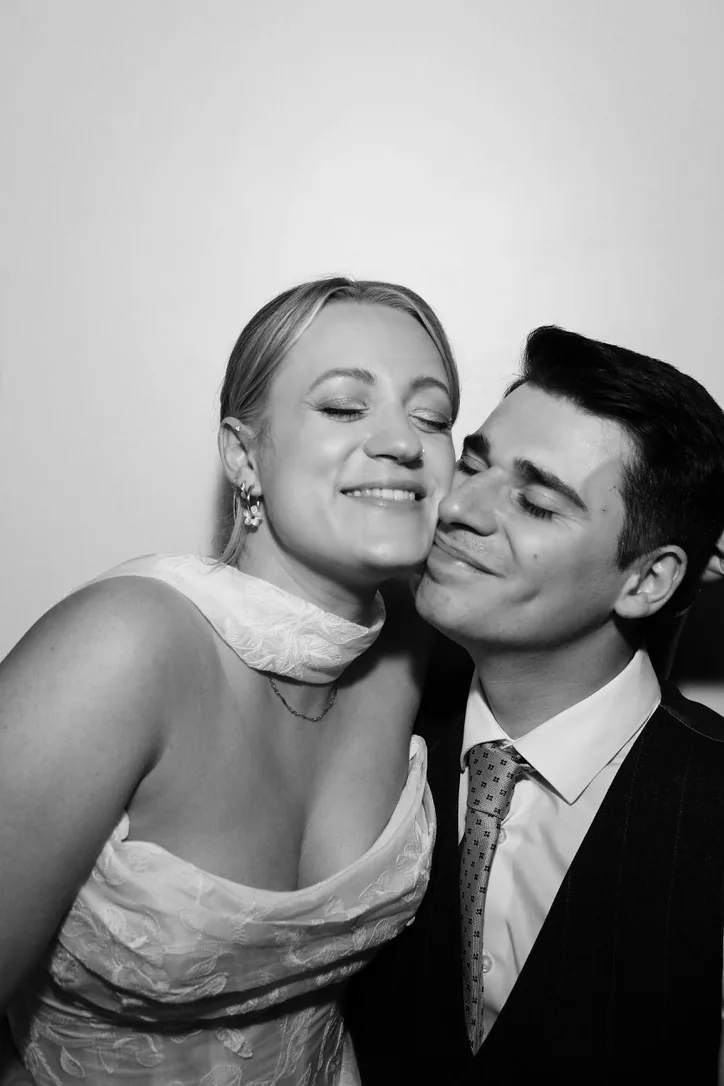 Newlyweds cheek to cheek in the Photomatic photo booth, black and white