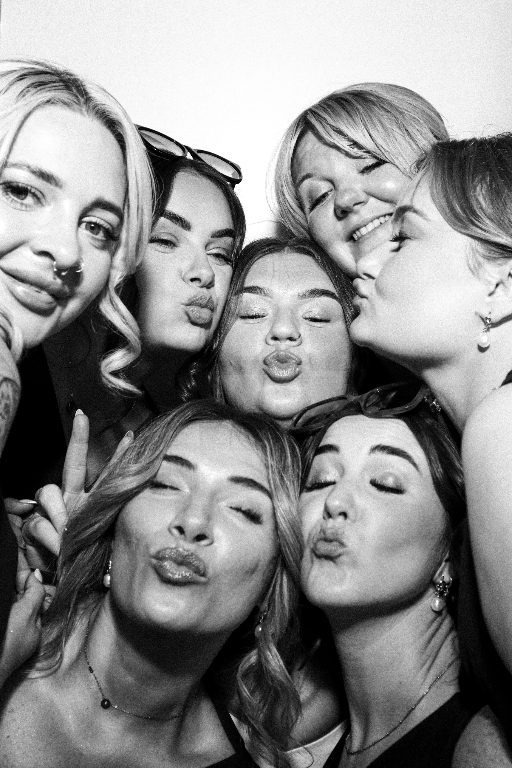 Bride and her friends pulling kiss faces together in the Photomatic photo booth