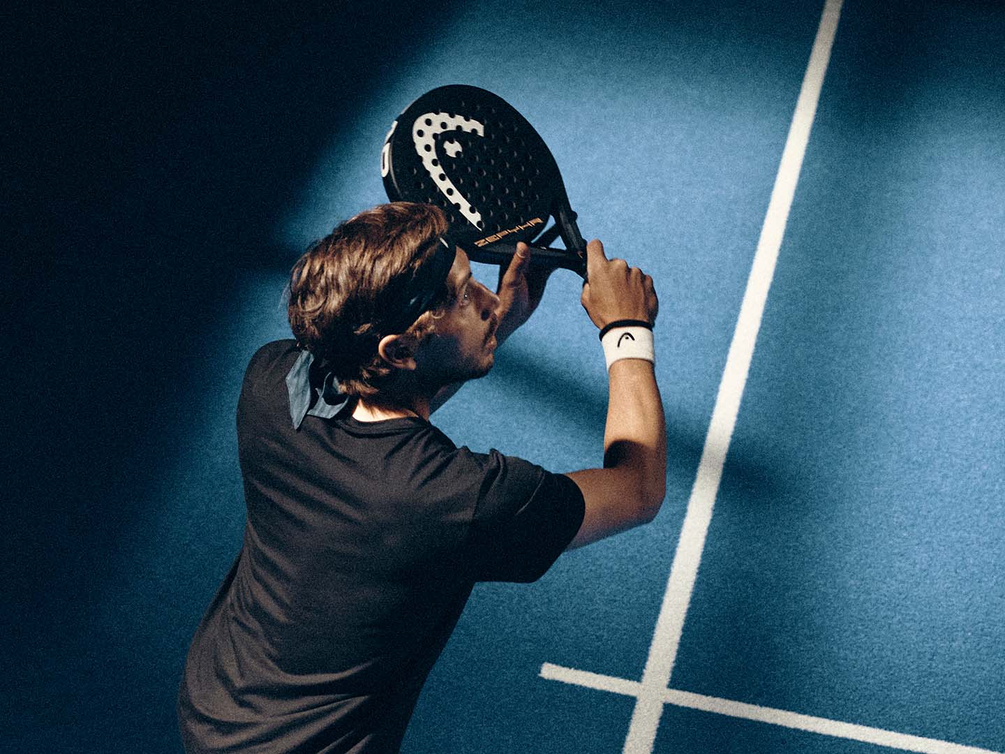 Padelspelare med Head-racket i blått ljus