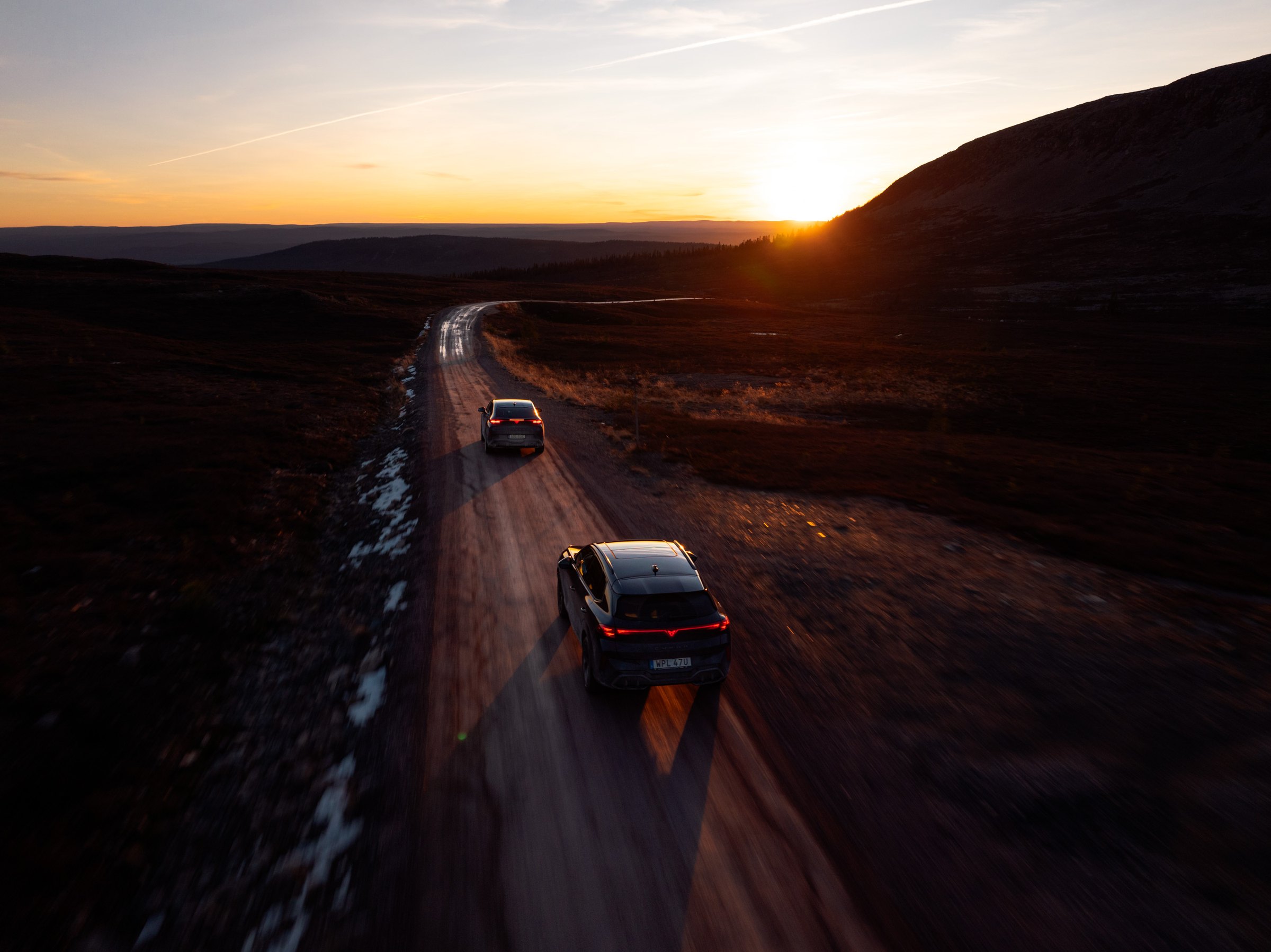 Två CUPRA på en grusväg över fjället i solnedgång