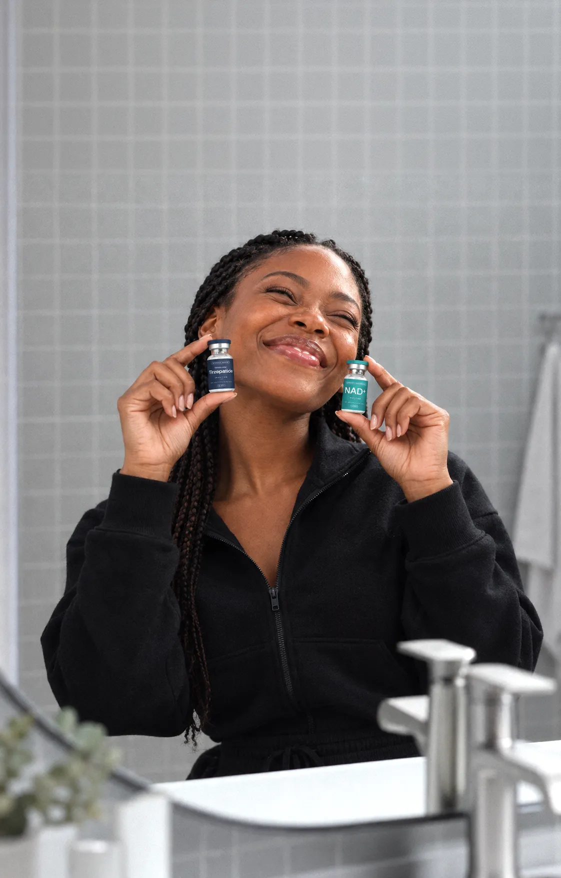 Woman holding two medication vials and smiling