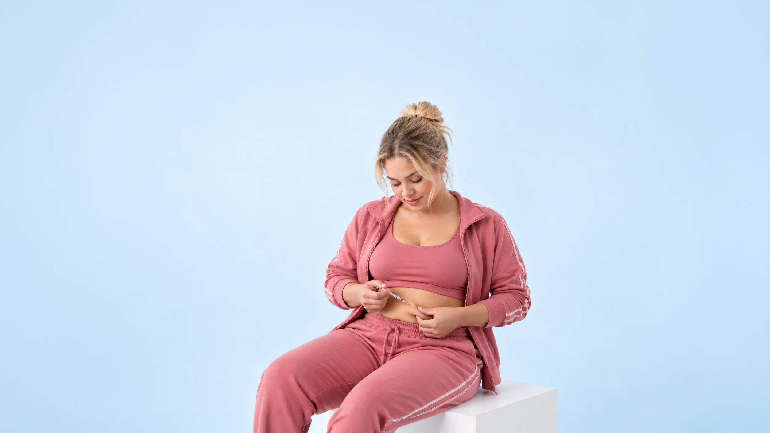 Woman administering a once-weekly subcutaneous injection at home