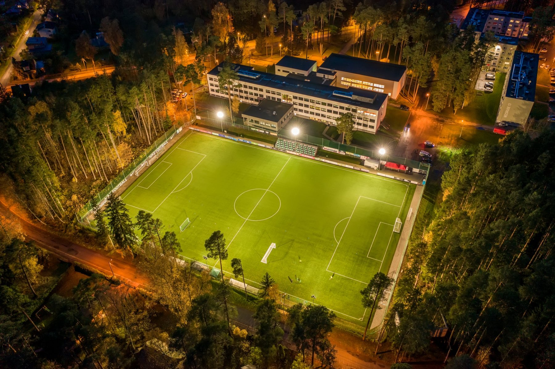 Nike Arena Elva valgustatud väljak õhtul männimetsa keskel
