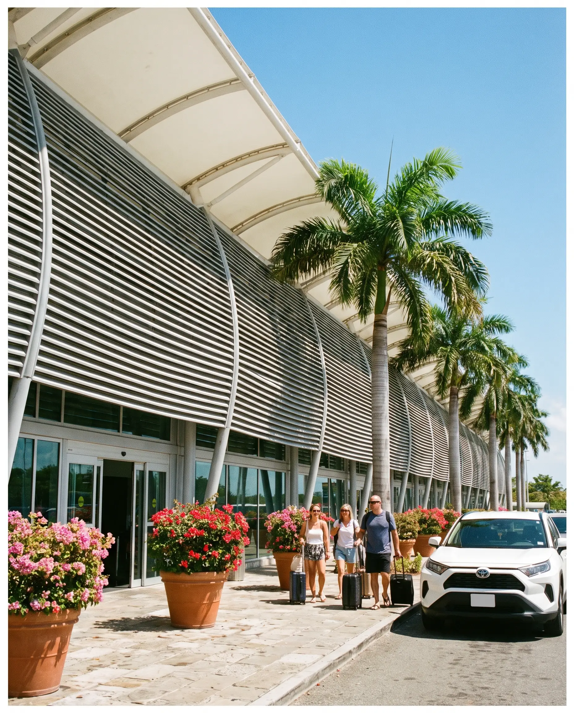 Curved louvered facade of the airport terminal with palm trees