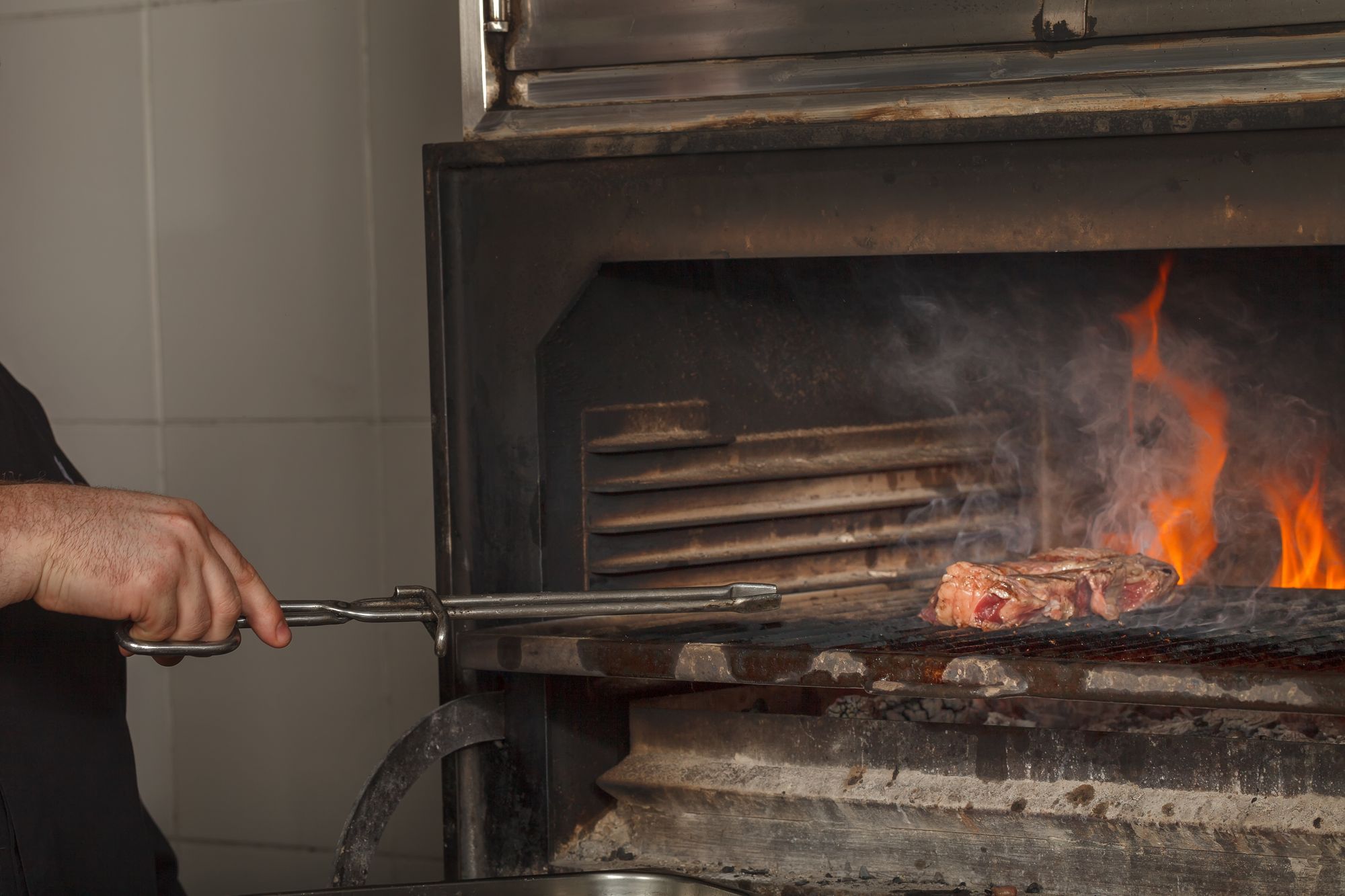 Cooking over embers on a wood-fired grill
