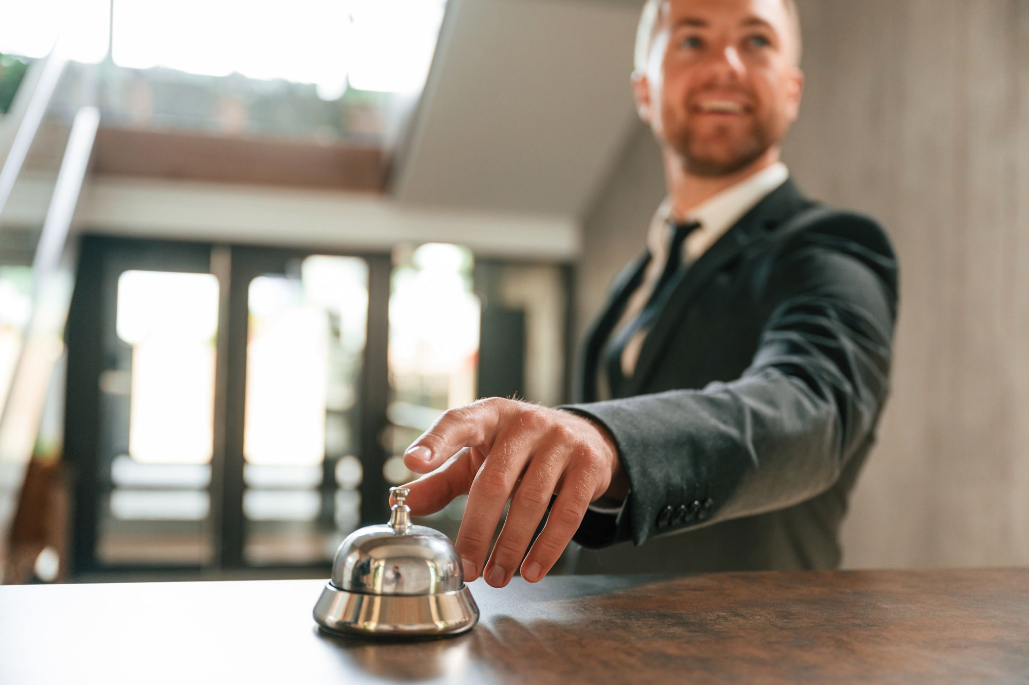Concierge ringing a service bell at a hotel desk