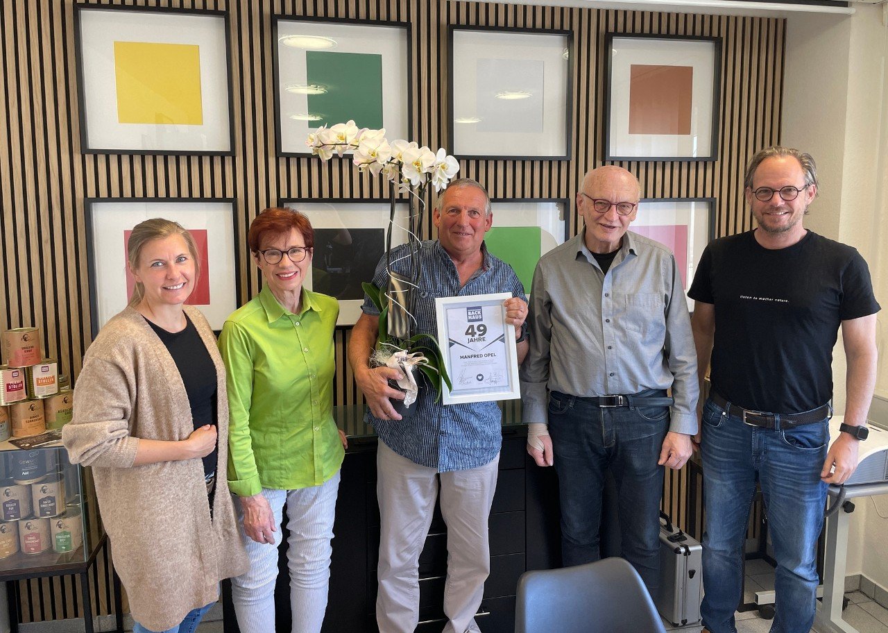 Manfred mit Urkunde zu 49 Jahren Betriebszugehörigkeit, umringt von Familie Fickenscher