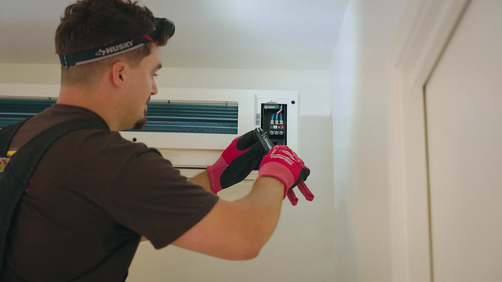 Installer setting up a newly mounted indoor heat pump unit