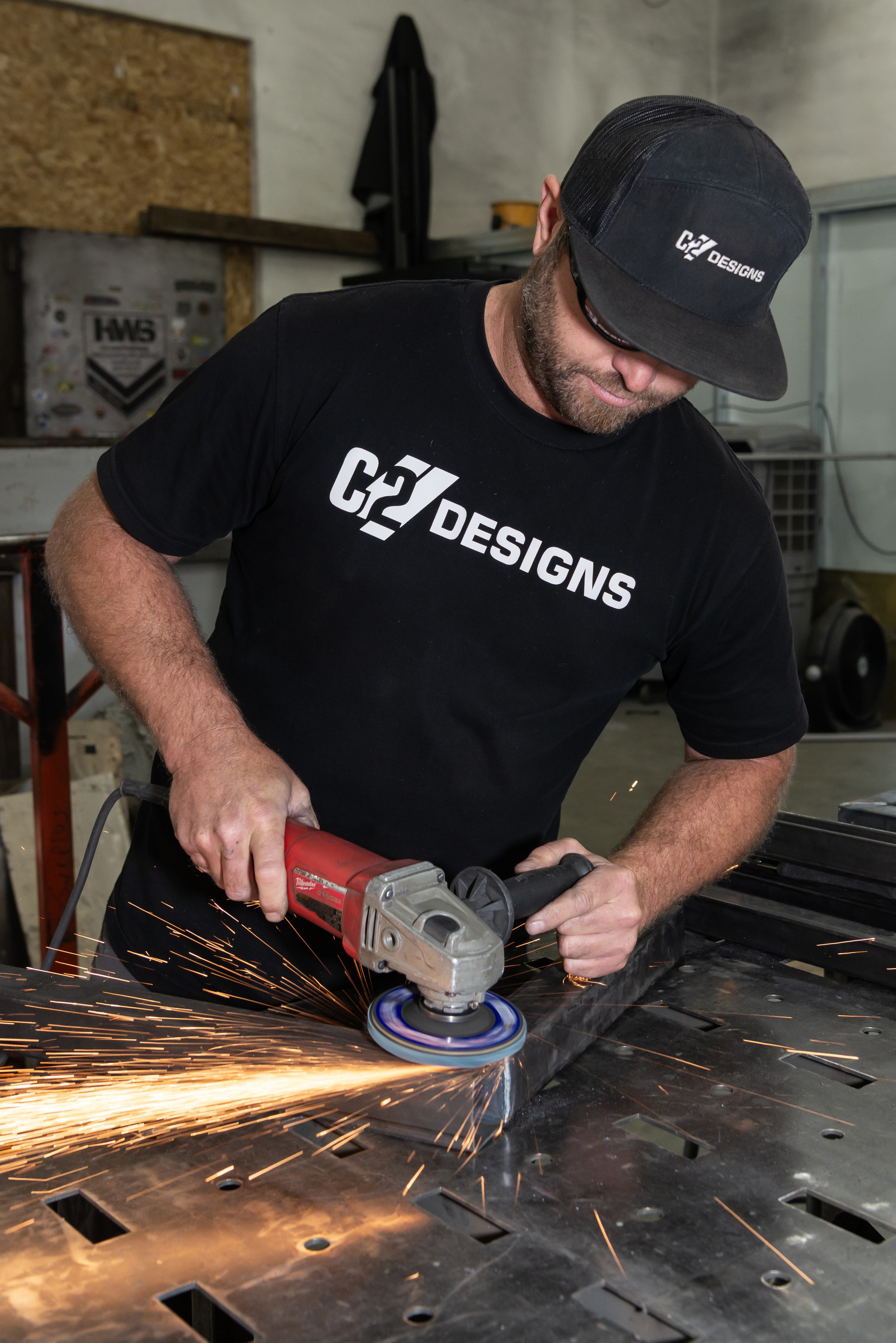 Grinding a steel frame in the workshop with sparks across the workbench