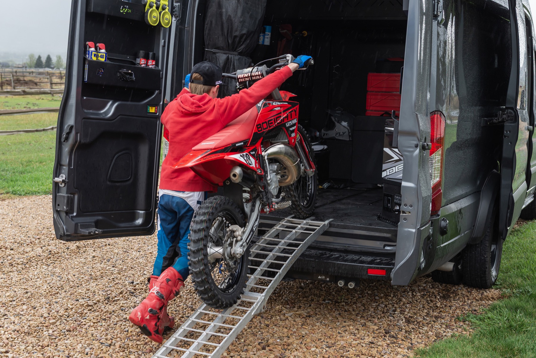 Rider loading a red motorcycle into a C2 custom van