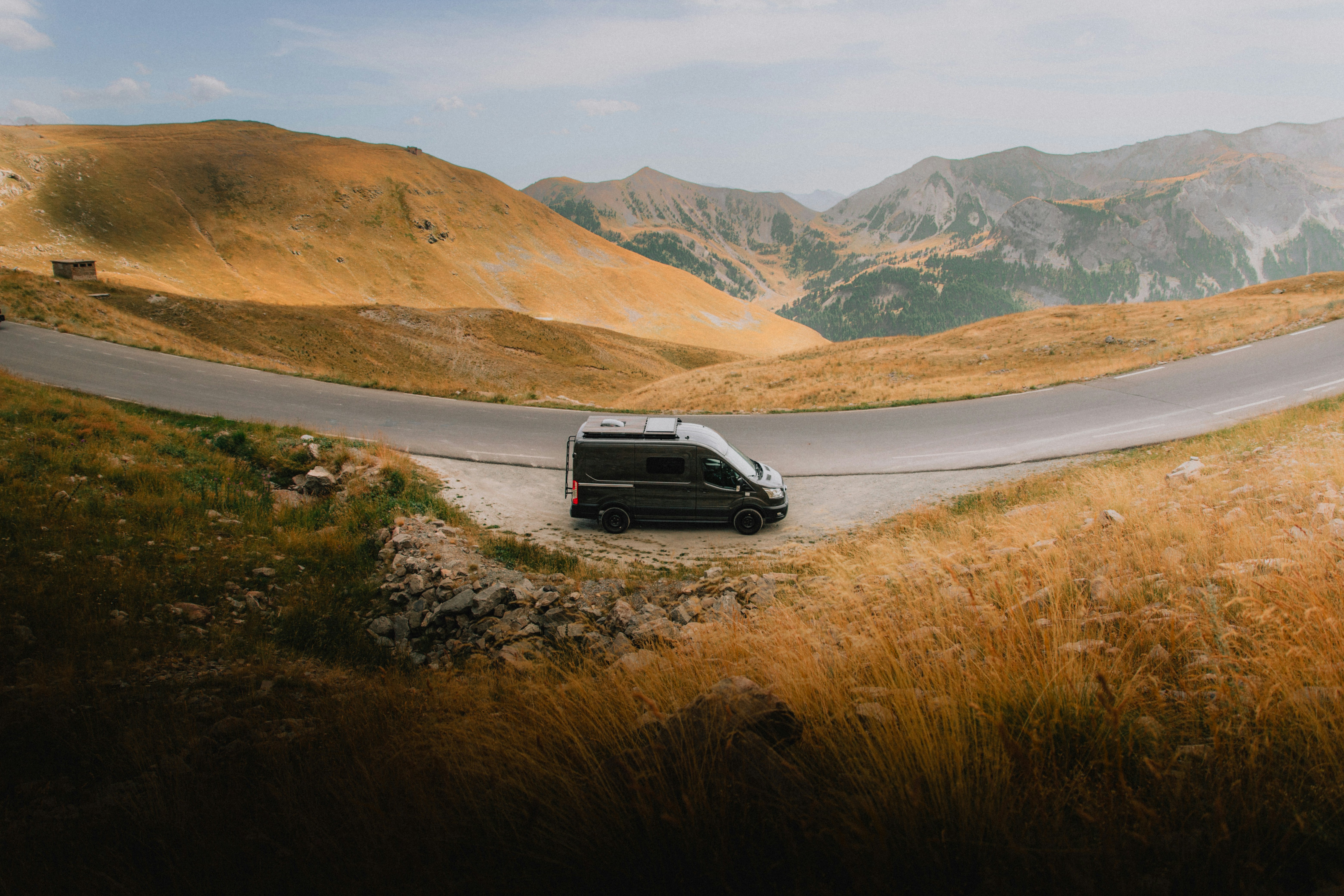 Camper van parked beside a winding mountain road