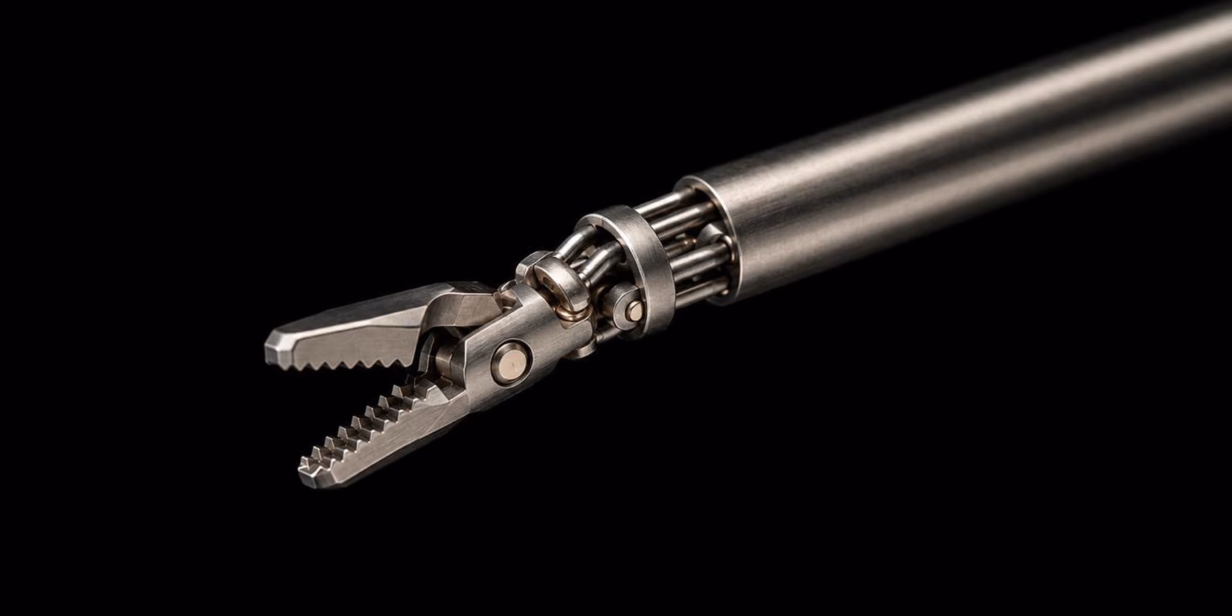 Close-up of a stainless steel robotic surgical grasper with serrated jaws on a black background.