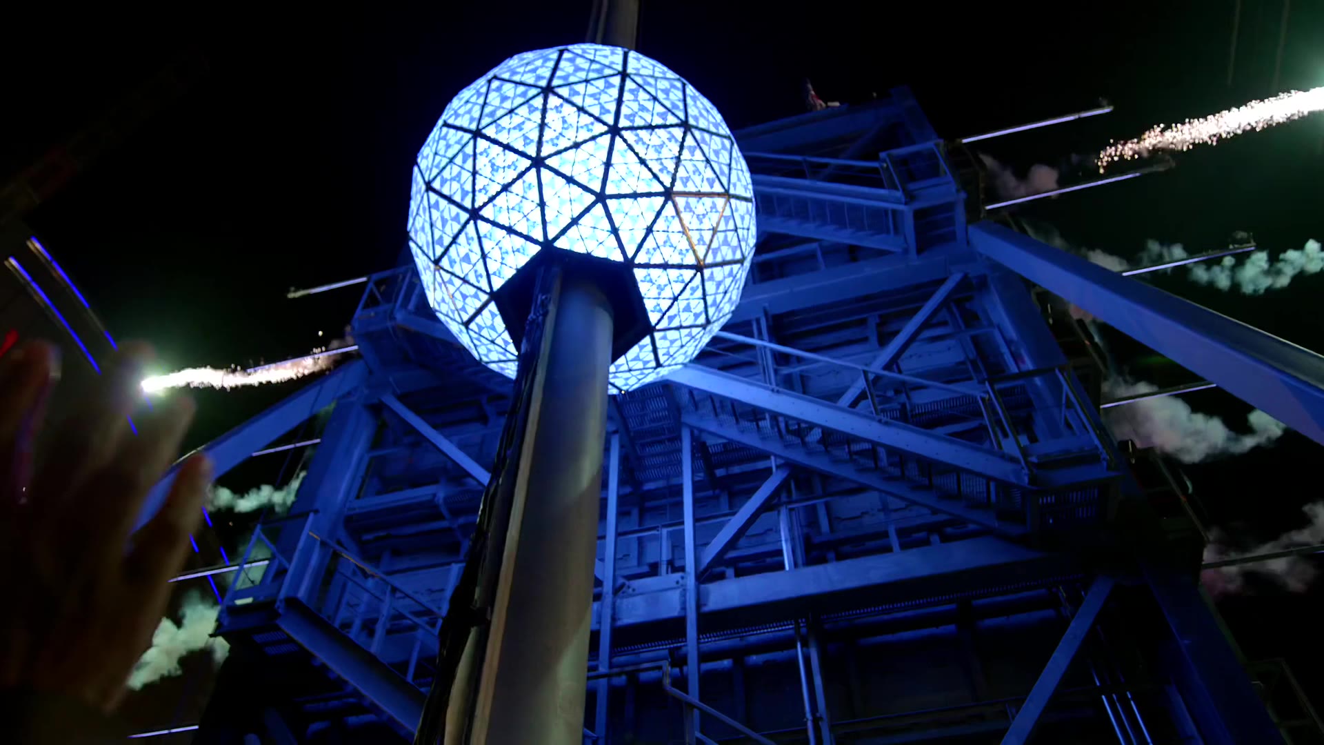 The Times Square New Year's Eve ball glowing blue at the top of its tower.