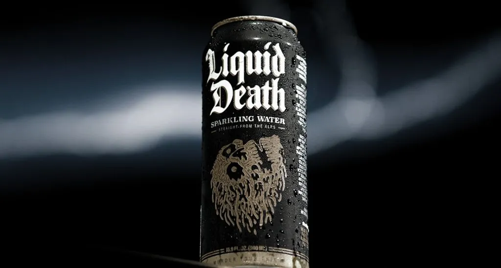 A cold can of Liquid Death sparkling water with condensation against a a black background.