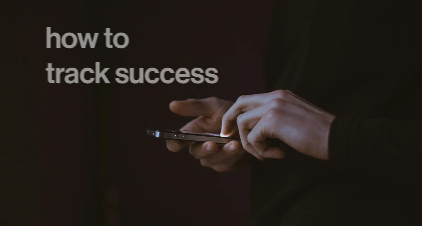 Hands typing on a phone with "how to track success" in the background for POLA Marketing's social media marketing guide