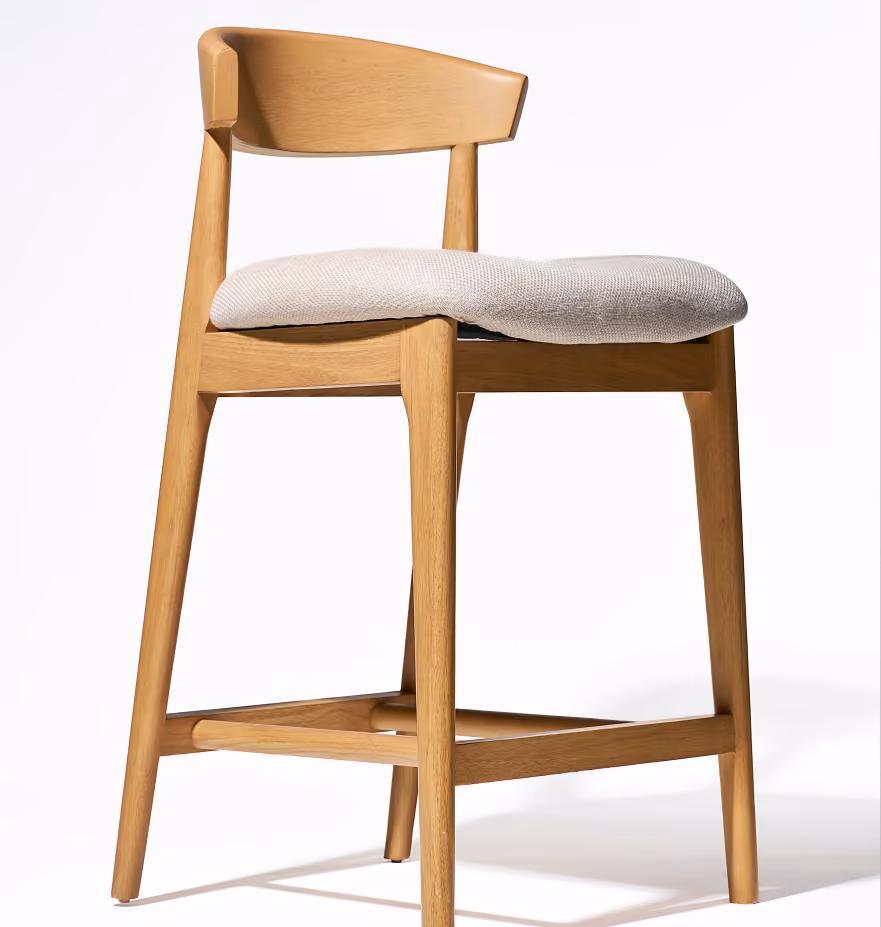 Wooden counter-height chair with a curved backrest and a light beige cushioned seat, shown on a white background.