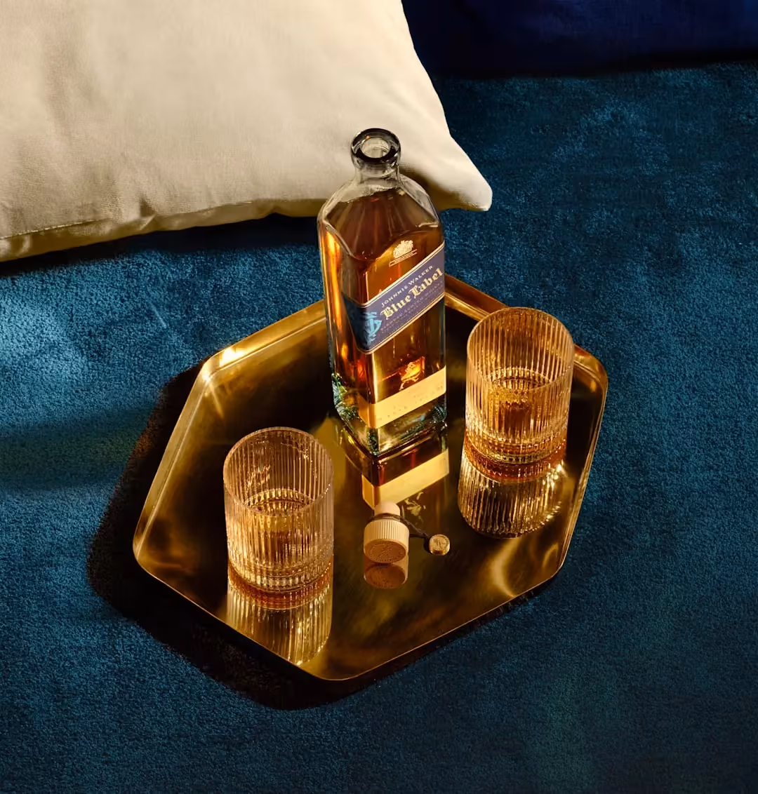 Johnnie Walker Blue Label bottle and two whisky glasses on a gold tray