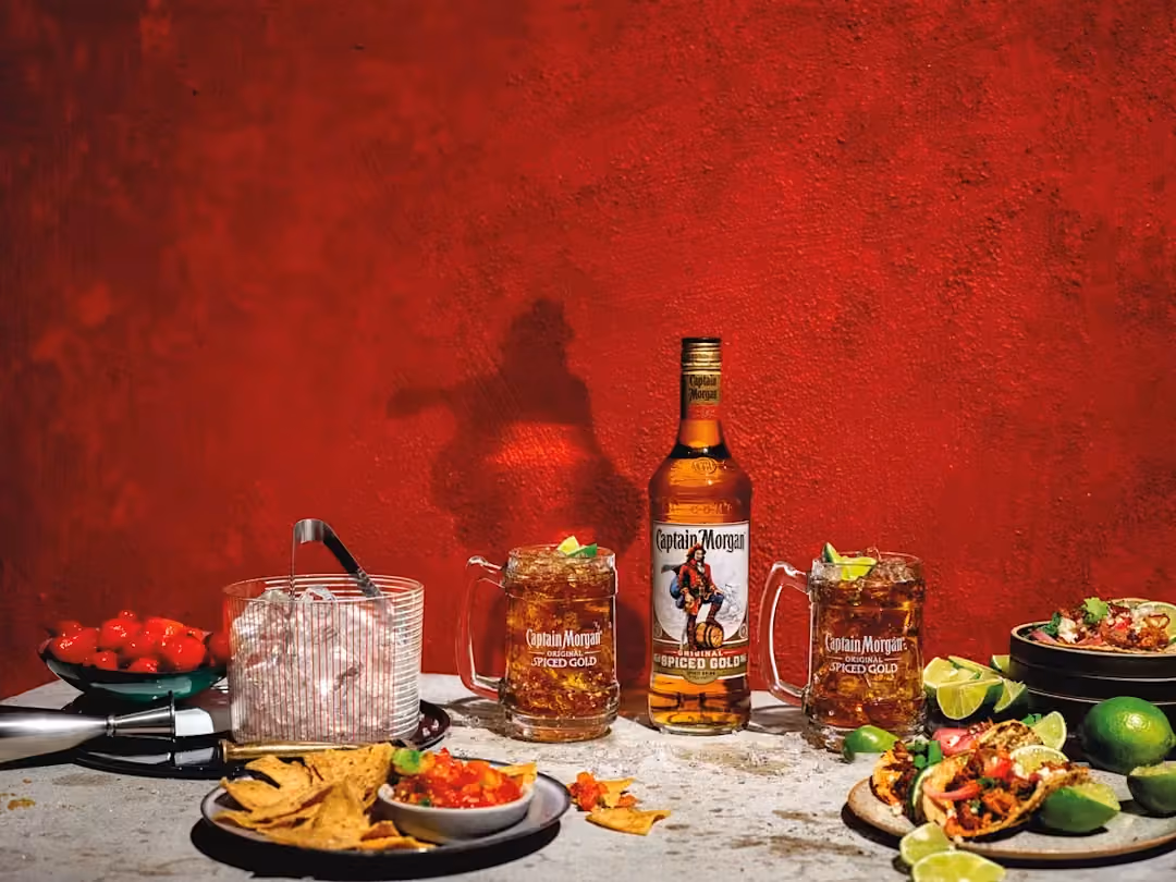 Captain Morgan Original Spiced Gold bottle with two mixed drinks and tacos