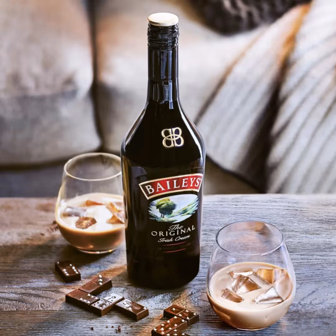 Baileys Original Irish Cream bottle with two glasses over ice