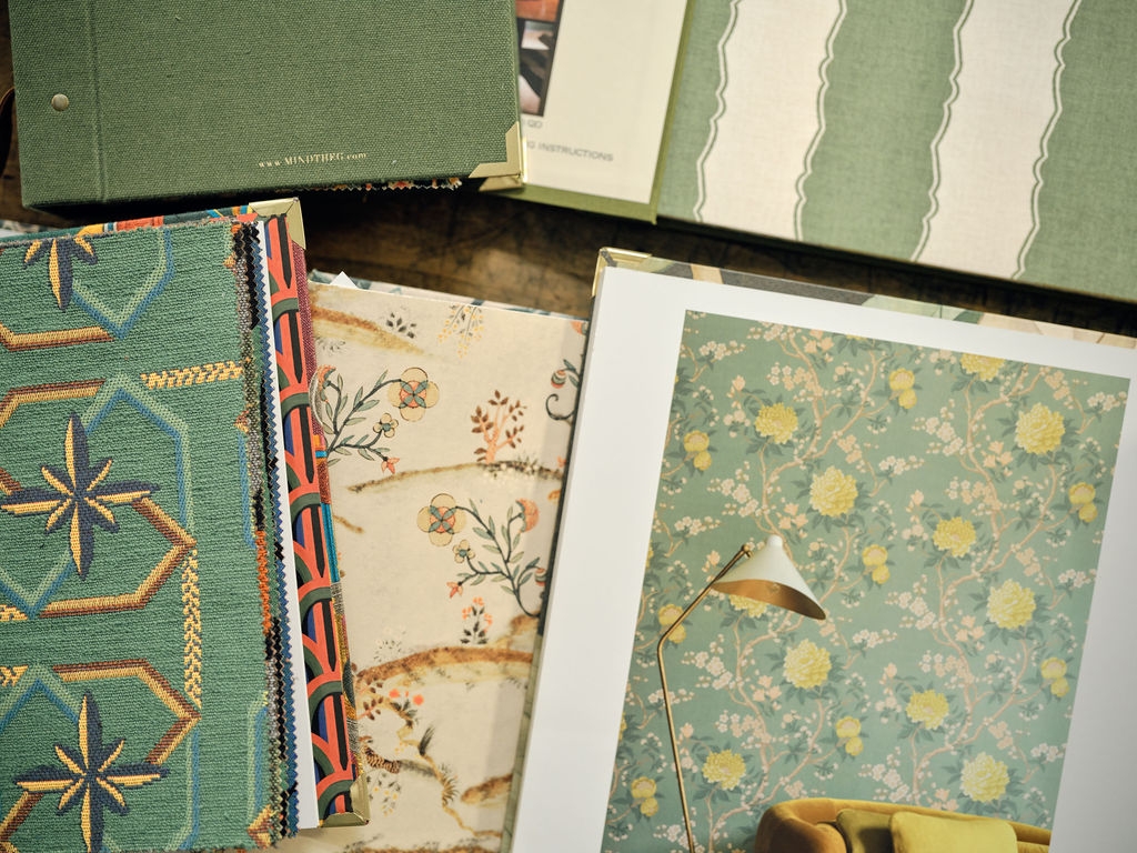 Overlapping wallpaper and fabric samples in green, blue and rust