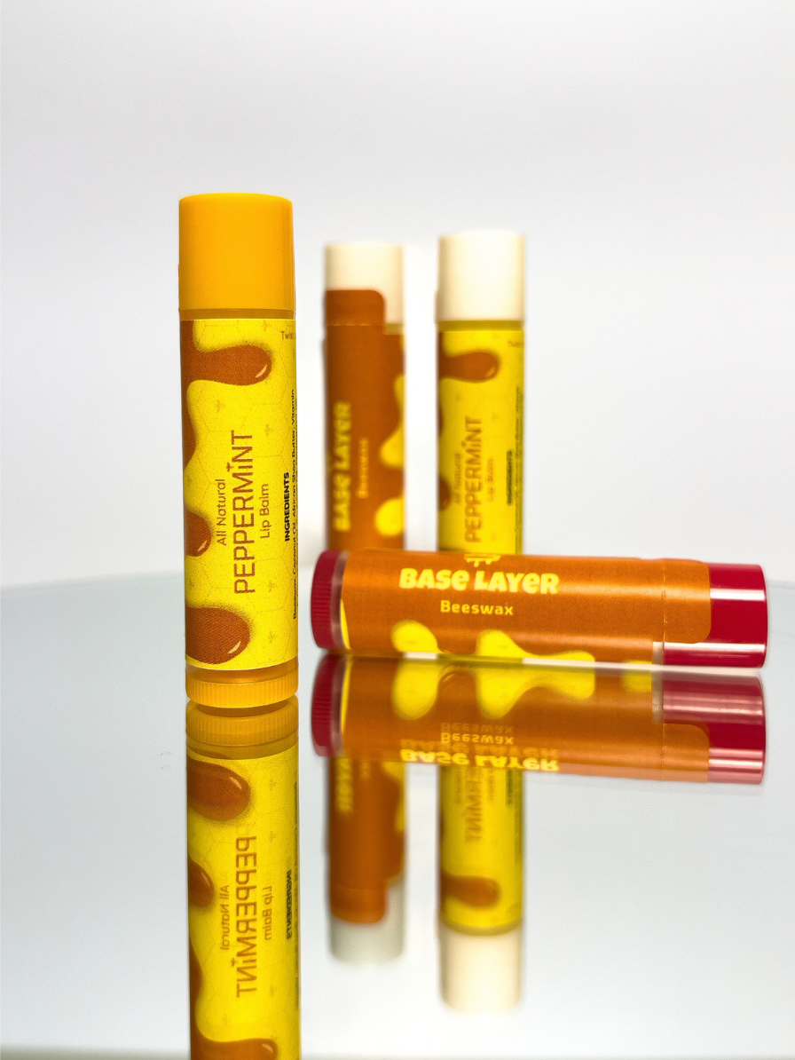 Peppermint and original Base Layer lip balms on a mirrored surface