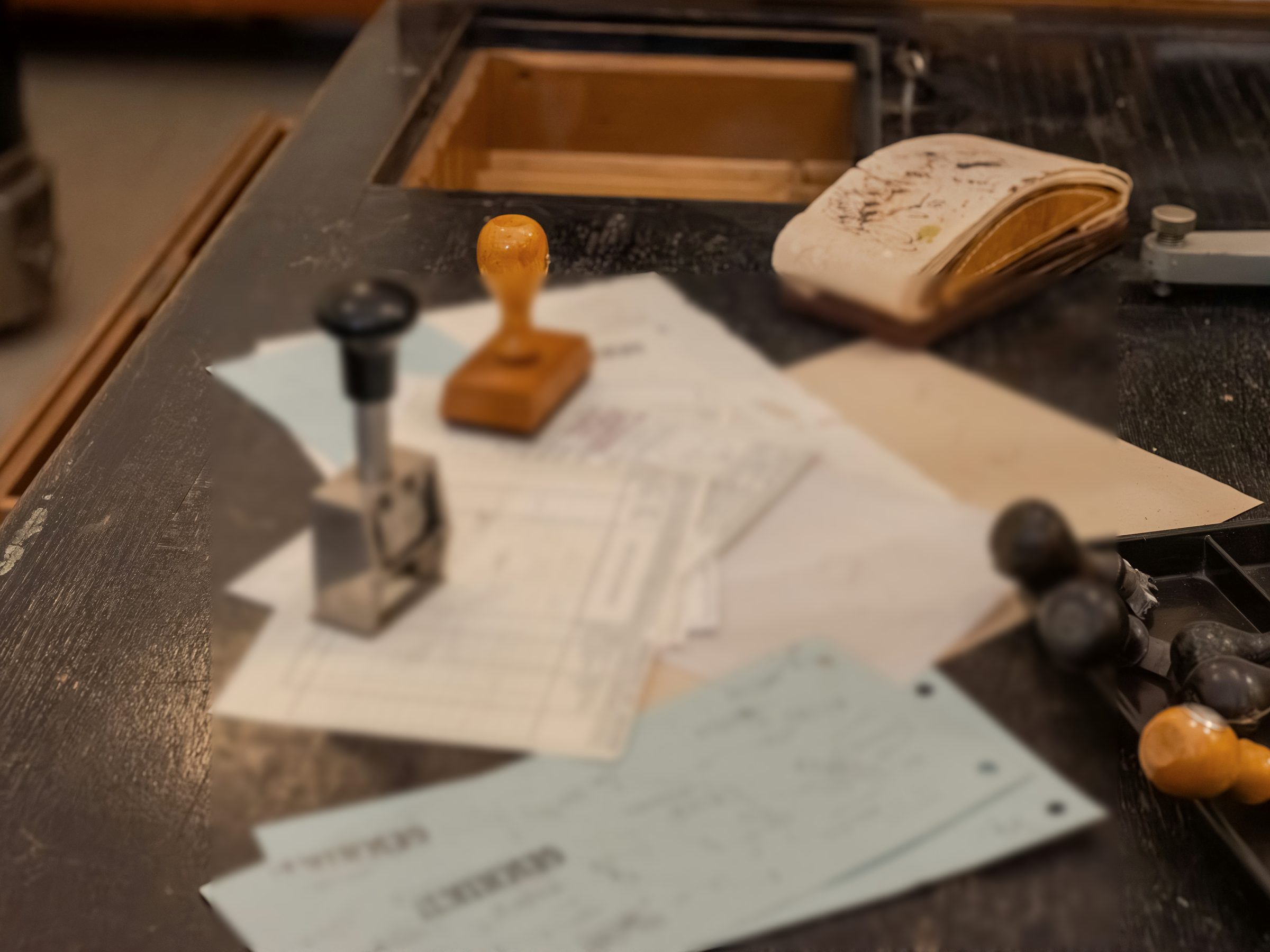 Rubber stamps and paper forms on a dark wooden counter