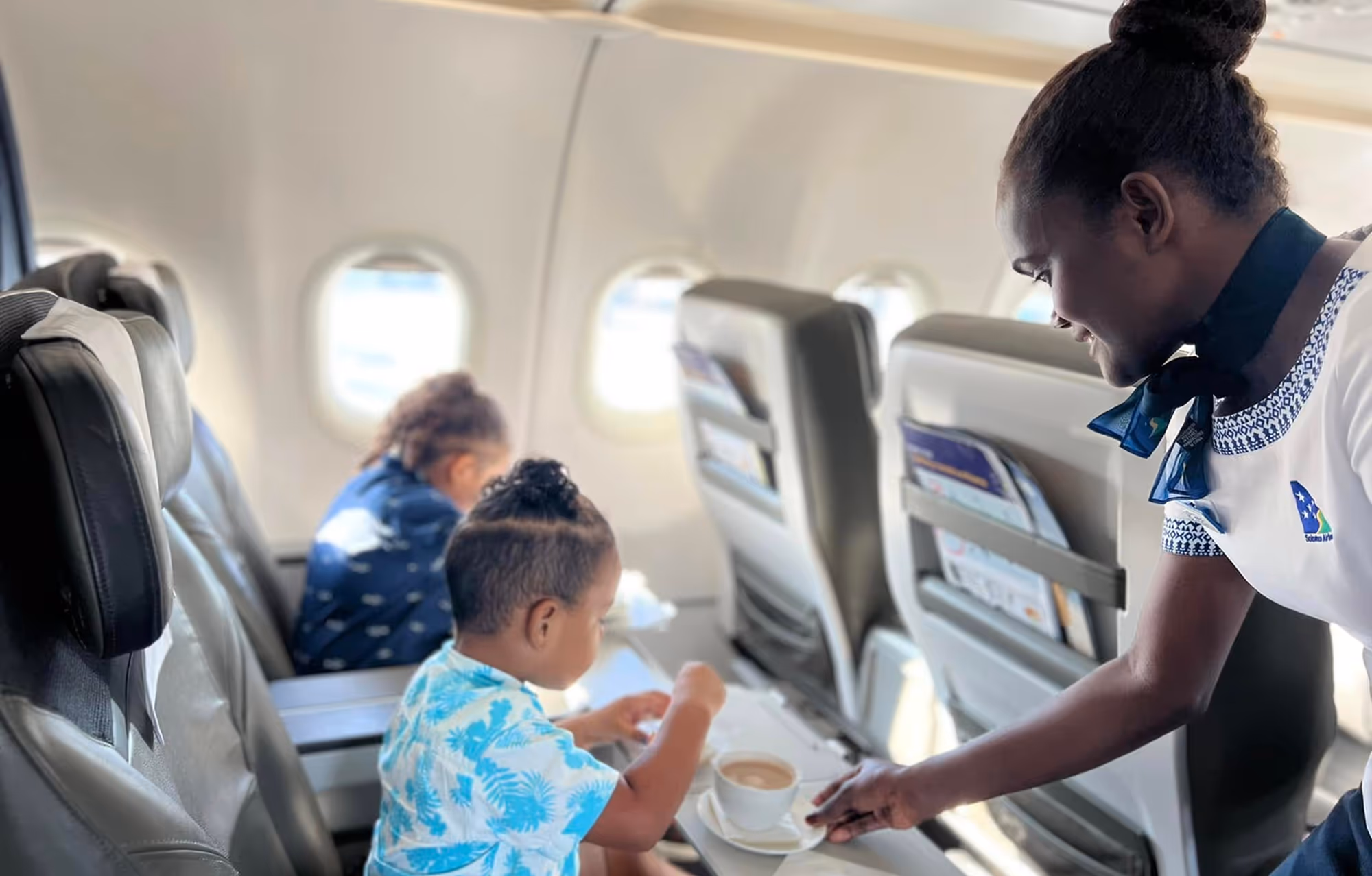 Solomon Air two children drinking KOSI hot chocolate as part of the in-flight service