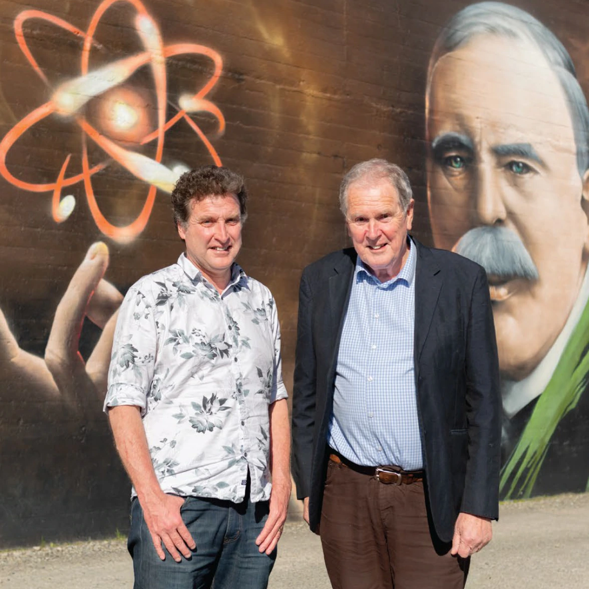 MARS Bioimaging founders standing in front of a mural of Ernest Rutherford and an atom