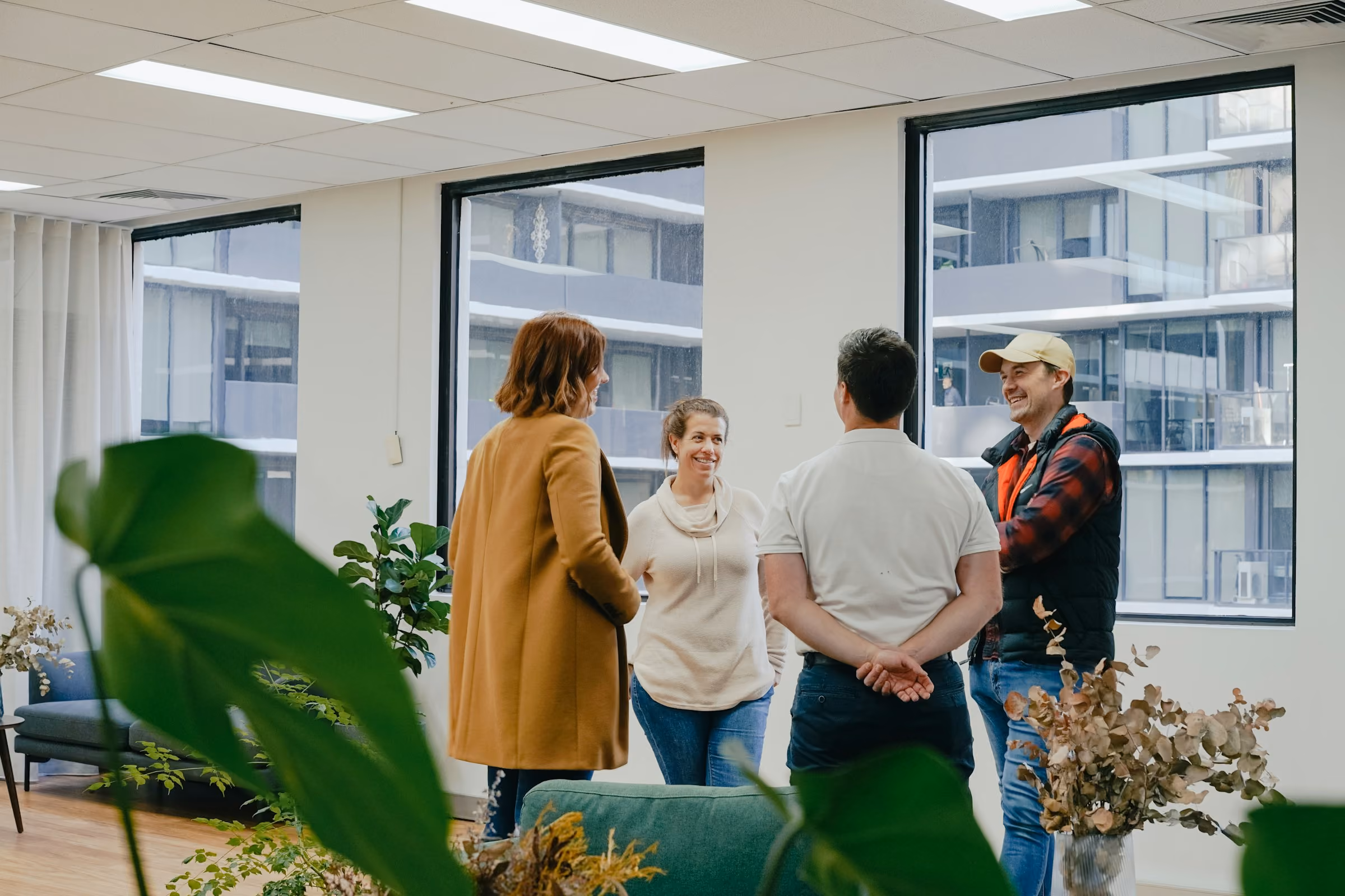 Une équipe échange debout dans un bureau lumineux