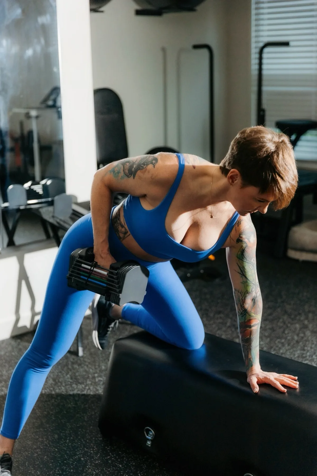 Kate Bolia demonstrating a dumbbell row in the Apex Dunwoody studio.