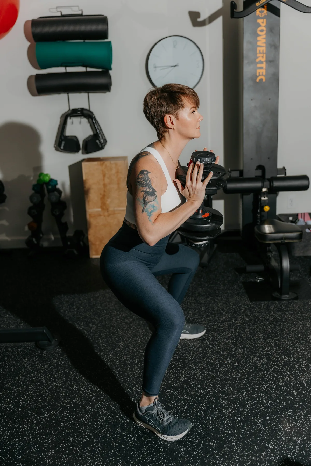 Kate Bolia demonstrating a weighted squat in the Apex Dunwoody studio.