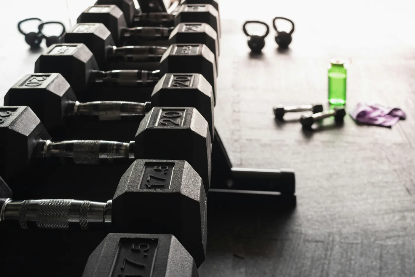 Stock photograph of black dumbbells arranged on a rack.