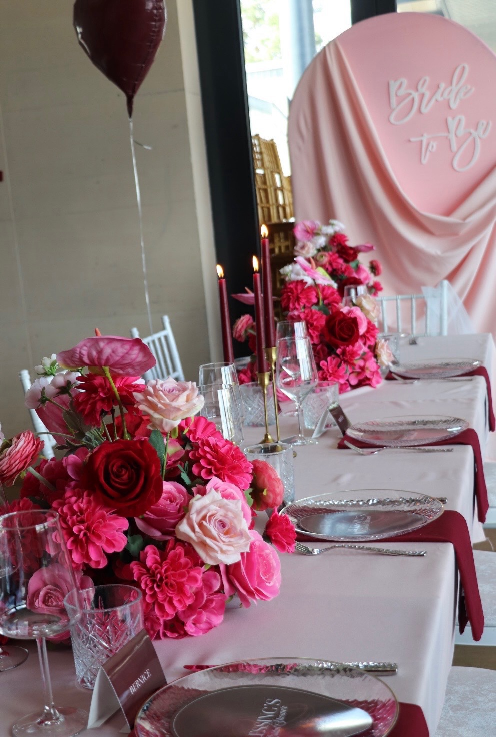 Bridal-Shower-Tafel mit Blumen und rosa Bride-to-be-Hintergrund.