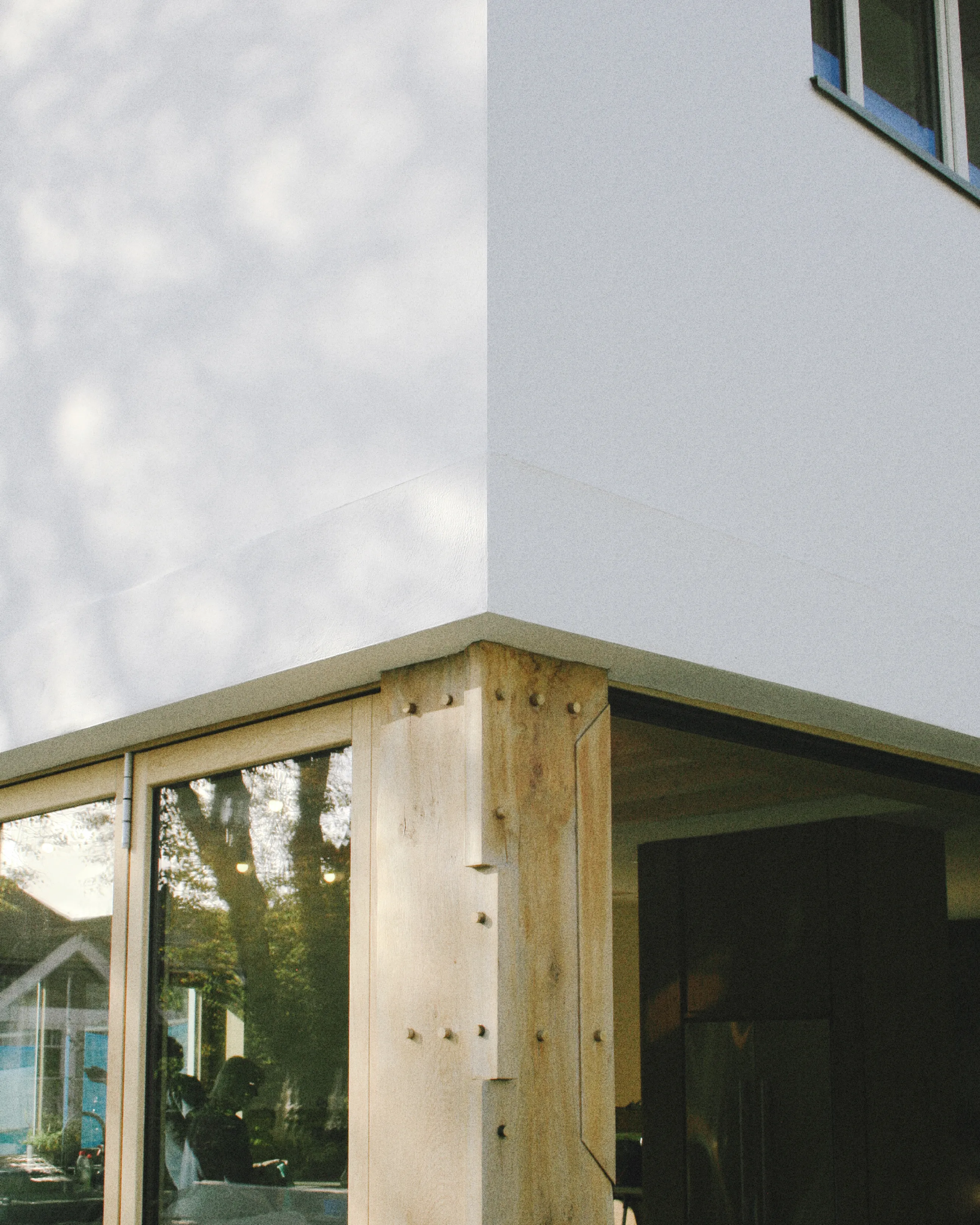 Timber-clad house with a zinc roof and large dormer windows
