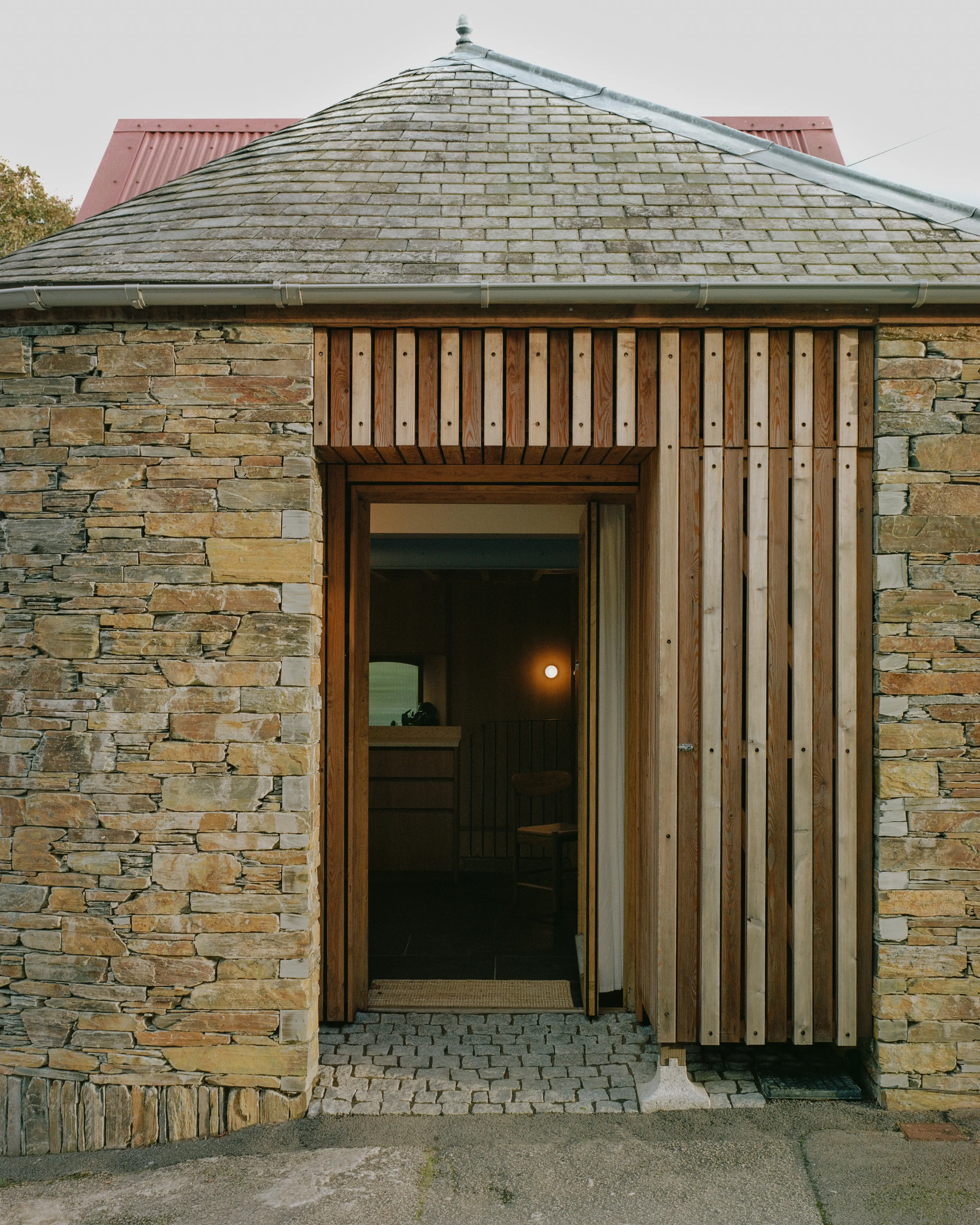 Timber post resting on a granite plinth set in cobbles