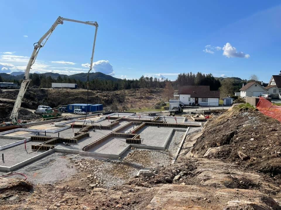 Fundamenter og ringmurer under støping med betongpumpe.